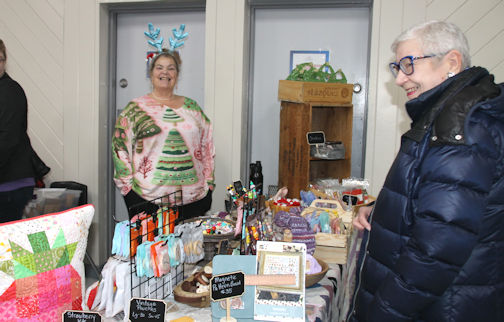 Debby MacFarlane (left) of Quilting By Design in Wingham, assists customers at the market|